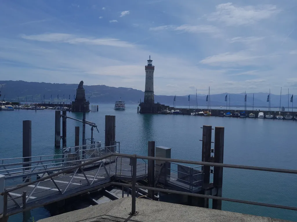 Ausflugsziel historische Altstadt mit der Hafeneinfahrt Löwe und Leuchtturm.
Im Hintergrund Aussicht auf die Berge Österreich und Schweiz