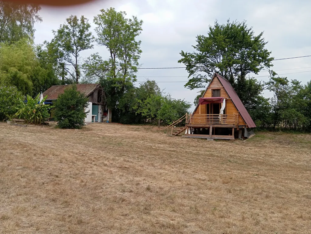 Photo du bungalow ainsi que les sanitaires du camping qui se trouvent dans la maison a gauche .