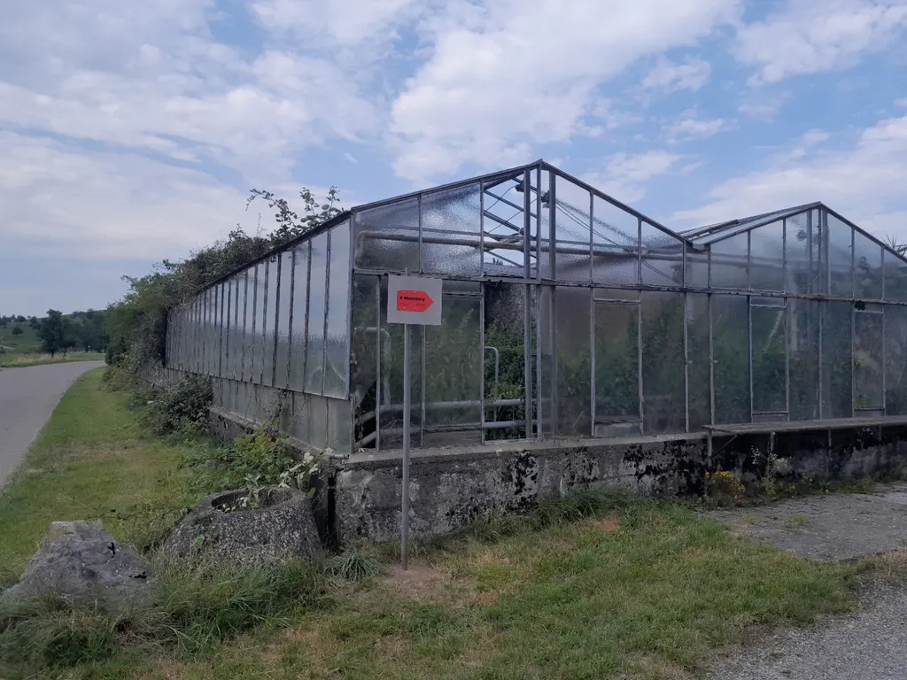 Hinweisschild von der Straße aus sichtbar direkt am alten Gewächshaus