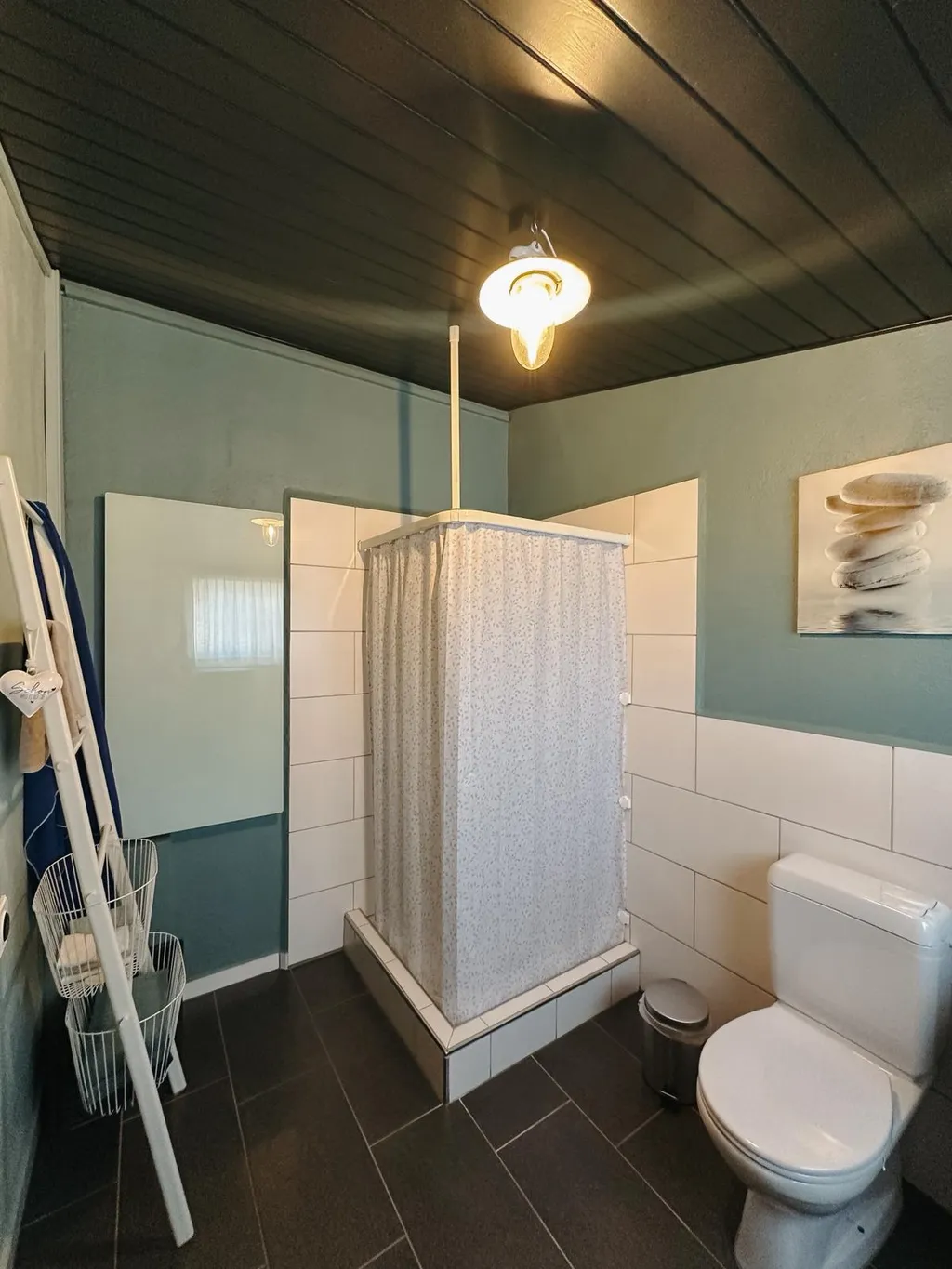 Das Bad befindet sich nicht im Podhouse, sondern etwa dreissig Meter davon entfernt in einem separaten Gebäude. Die Unterkunft verfügt über zwei Bäder: eines mit Toilette, Lavabo und Dusche und eines mit Toilette und Lavabo. Frische Duschtücher und Handtücher werden zur Verfügung gestellt, ebenso wie verschiedene Pflegeprodukte und ein Haartrockner.