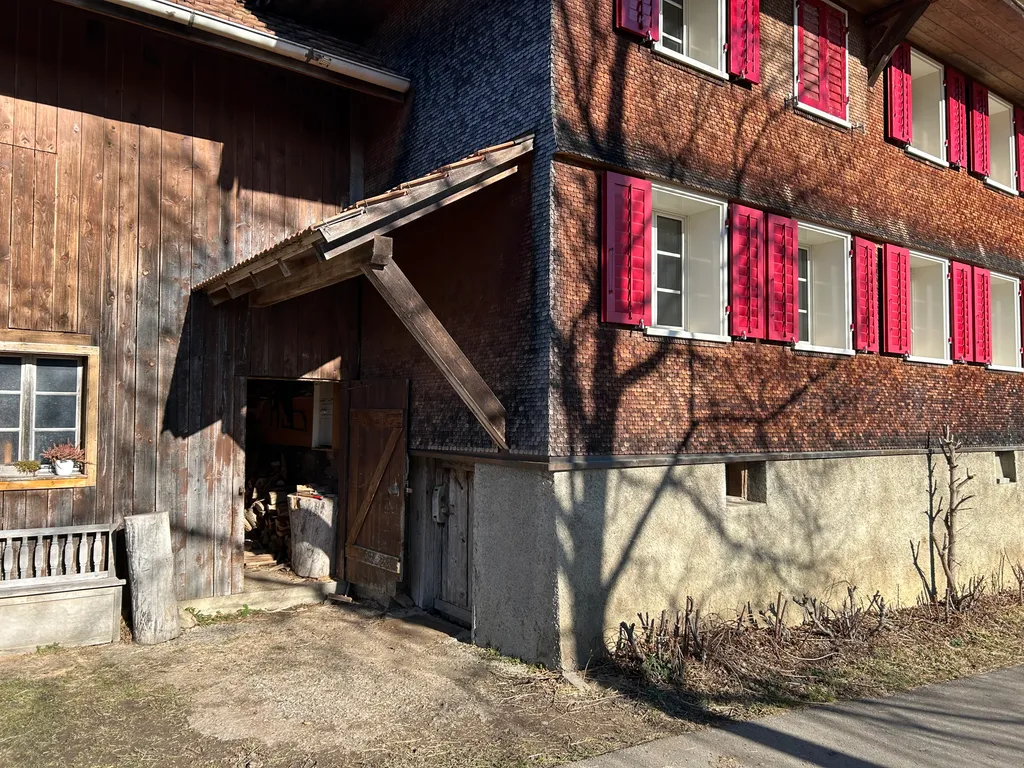 Zwischen Haus und Hofladen befindet sich der Eingang um Holz zu holen, zur Küche und Toilette.