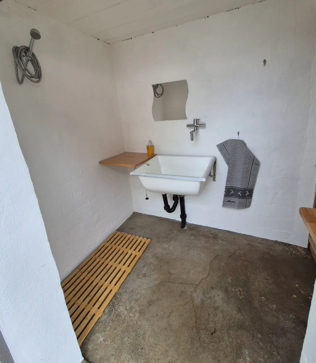 Ein eigener Raum mit einem grossen Waschbecken und einer warmwasser Dusche steht zur verfügung