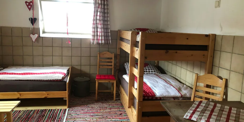 Im Zimmer befindet sich ein Stockbett, ein Einzelbett und ein Sofa das zum Doppelbett ausgeklappt werden kann